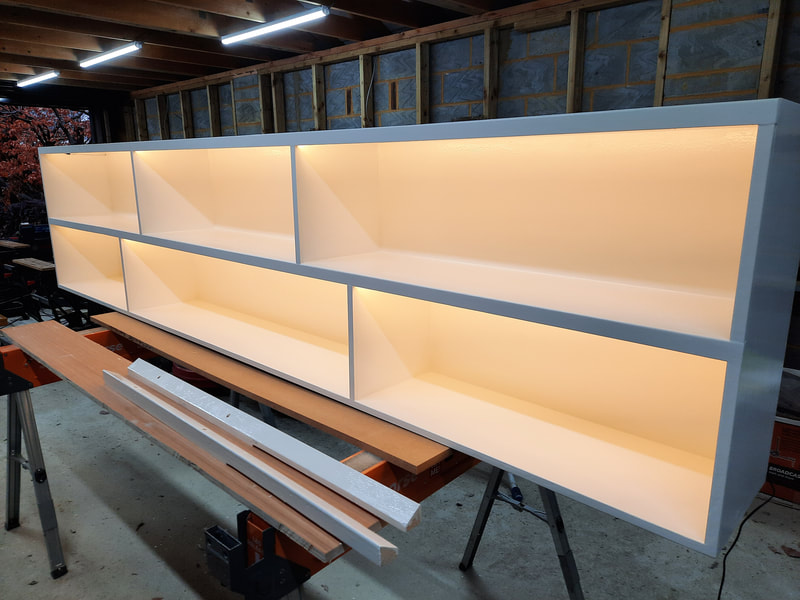 White shelving with in-built LED lighting, lights switched on