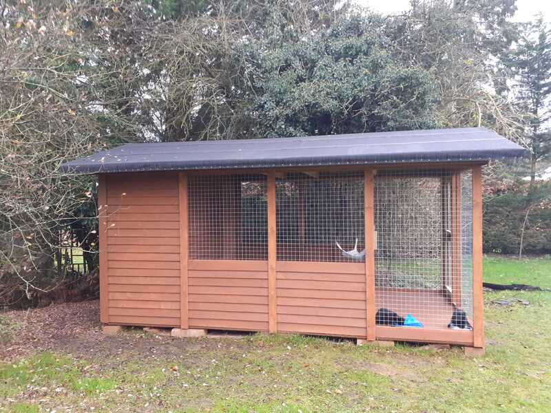 Picture of the finished catio, stained in medium oak, with a black felted roof