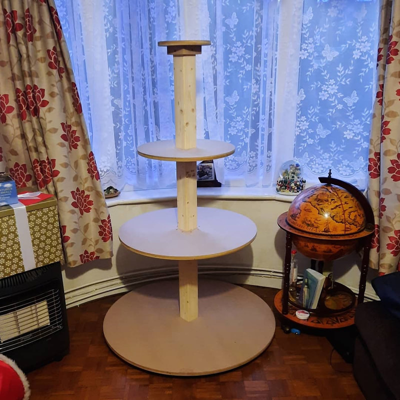 Christmas village tree display stand, four circles, decreasing in size from bottom to top on a post, in a Christmas tree shape